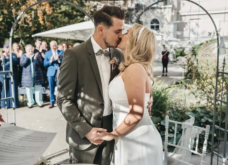 Brautpaar küsst sich im Schloss Styrum