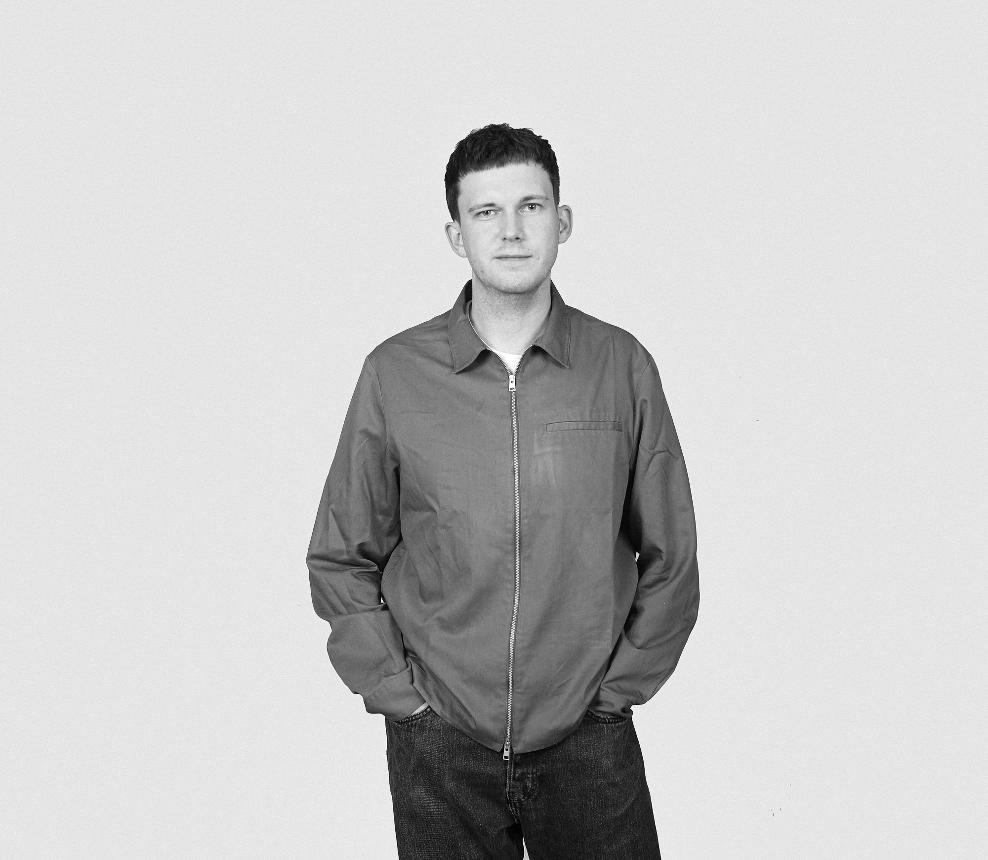Black and white portrait photo of Johannes standing in front of a plain background