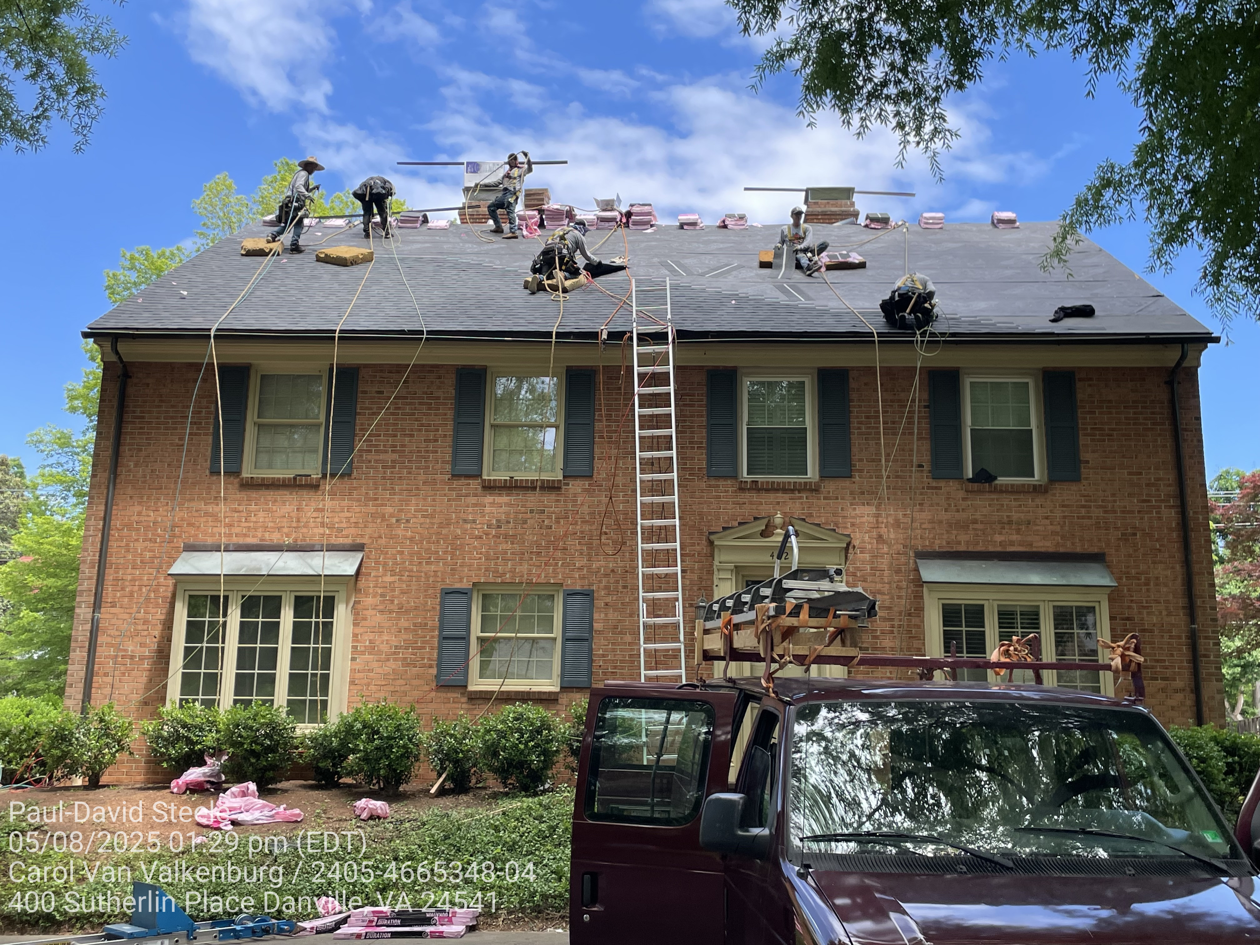 Several workers installing a new shingle roof.
