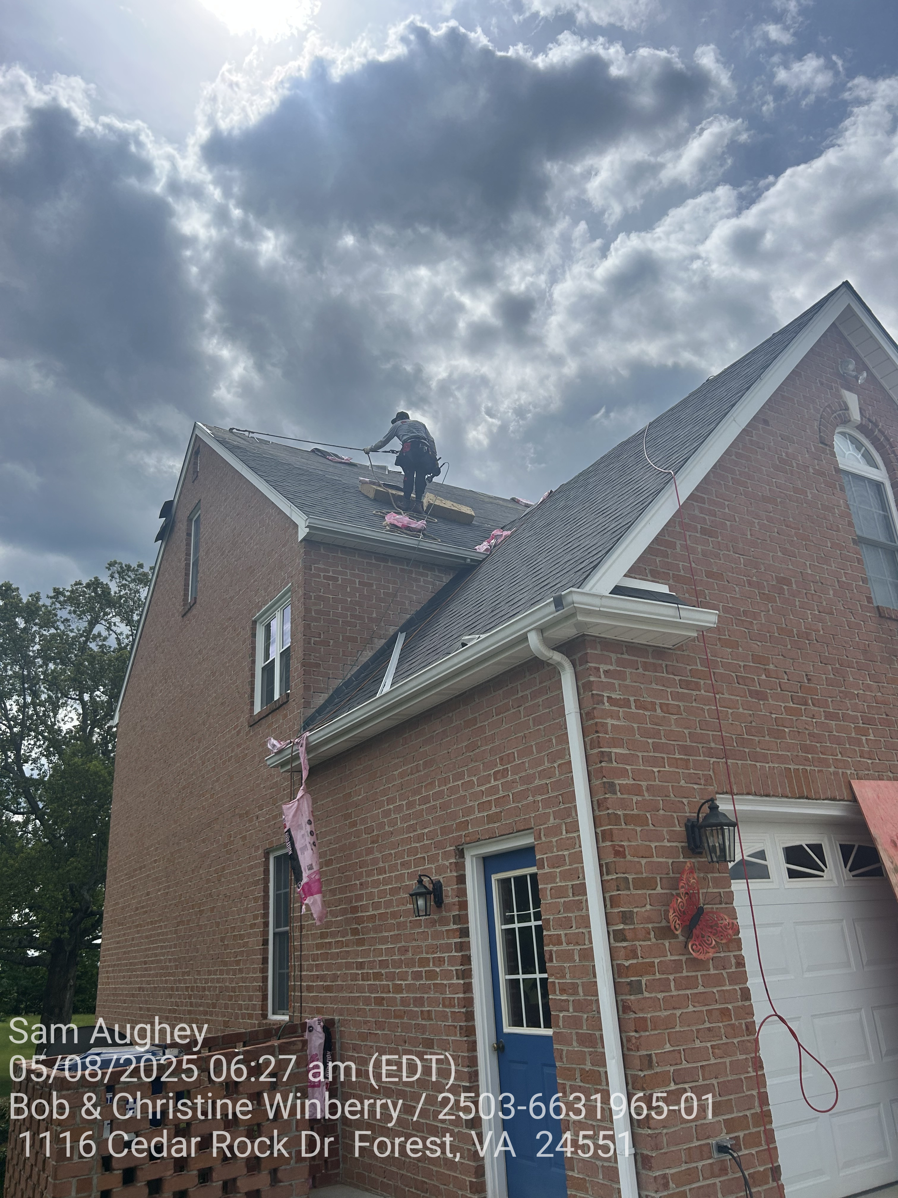 A brick house with Onyx Black shingles on it.