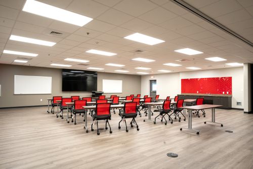 A conference room featuring several tables and chairs arranged for meetings.