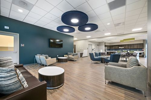 A cozy room featuring multiple couches and chairs arranged for comfort, with a coffee table in the center.