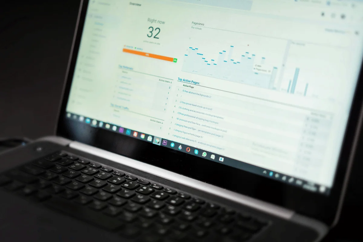 Laptop screen displaying website analytics dashboard with active users, pageviews, and traffic reports.