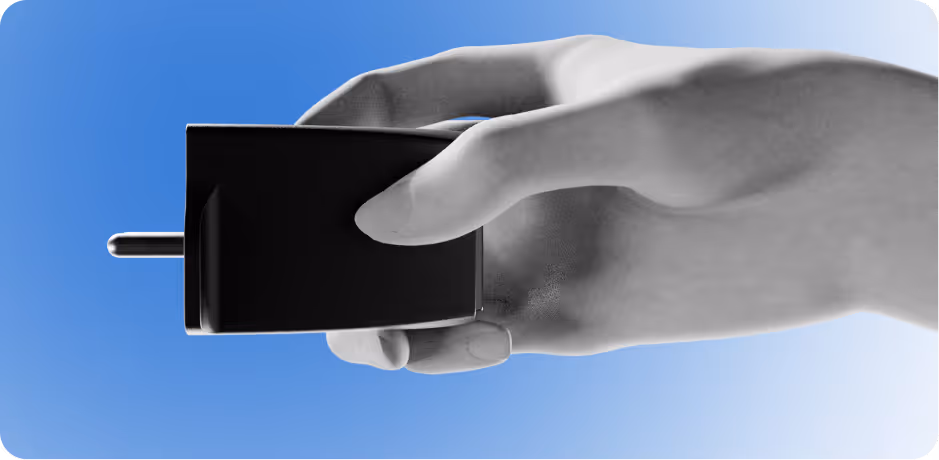 Hand holding a black electrical plug adapter against a blue to white gradient background.