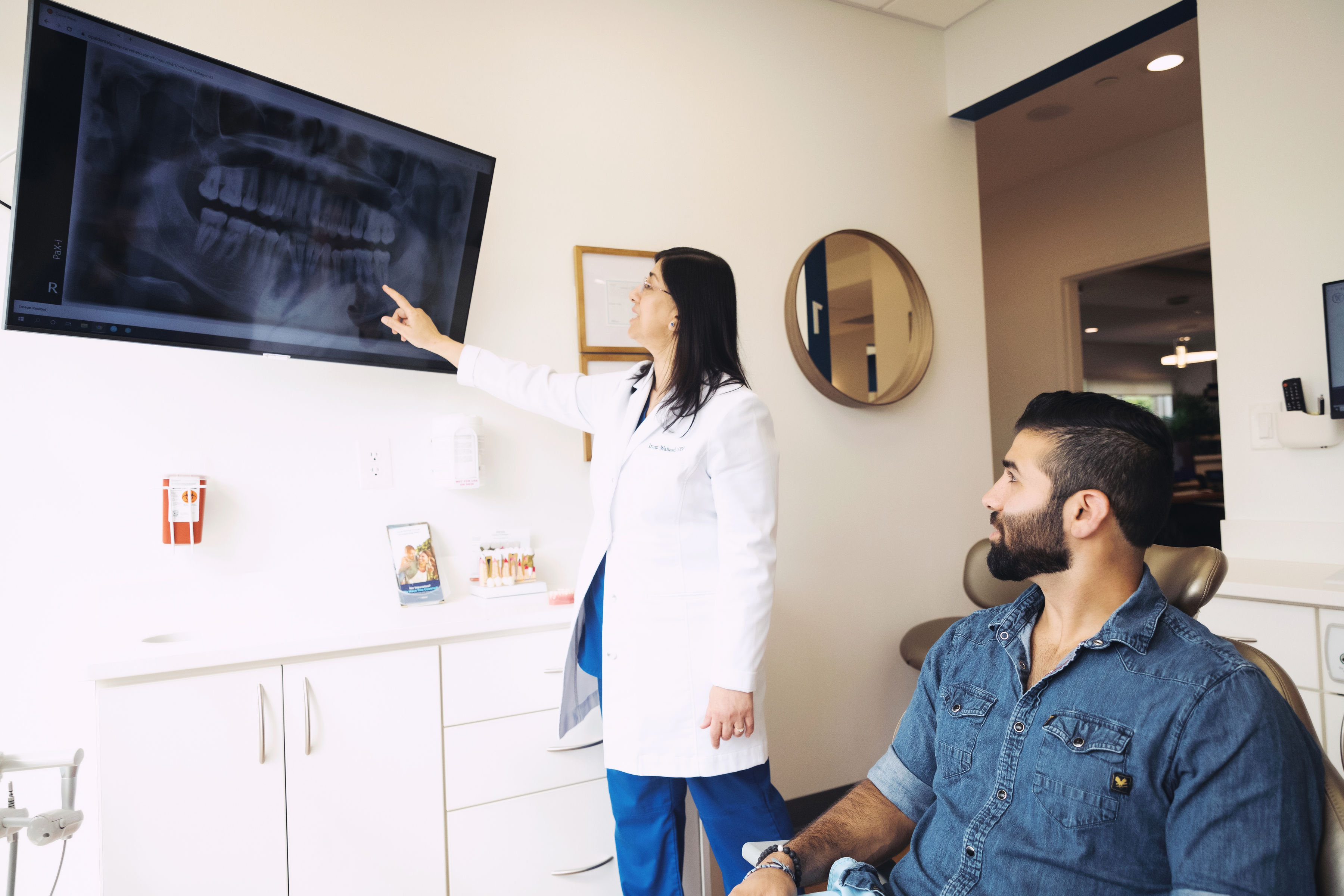 Dentist at pal Dental Group showing a patient x-ray scans.