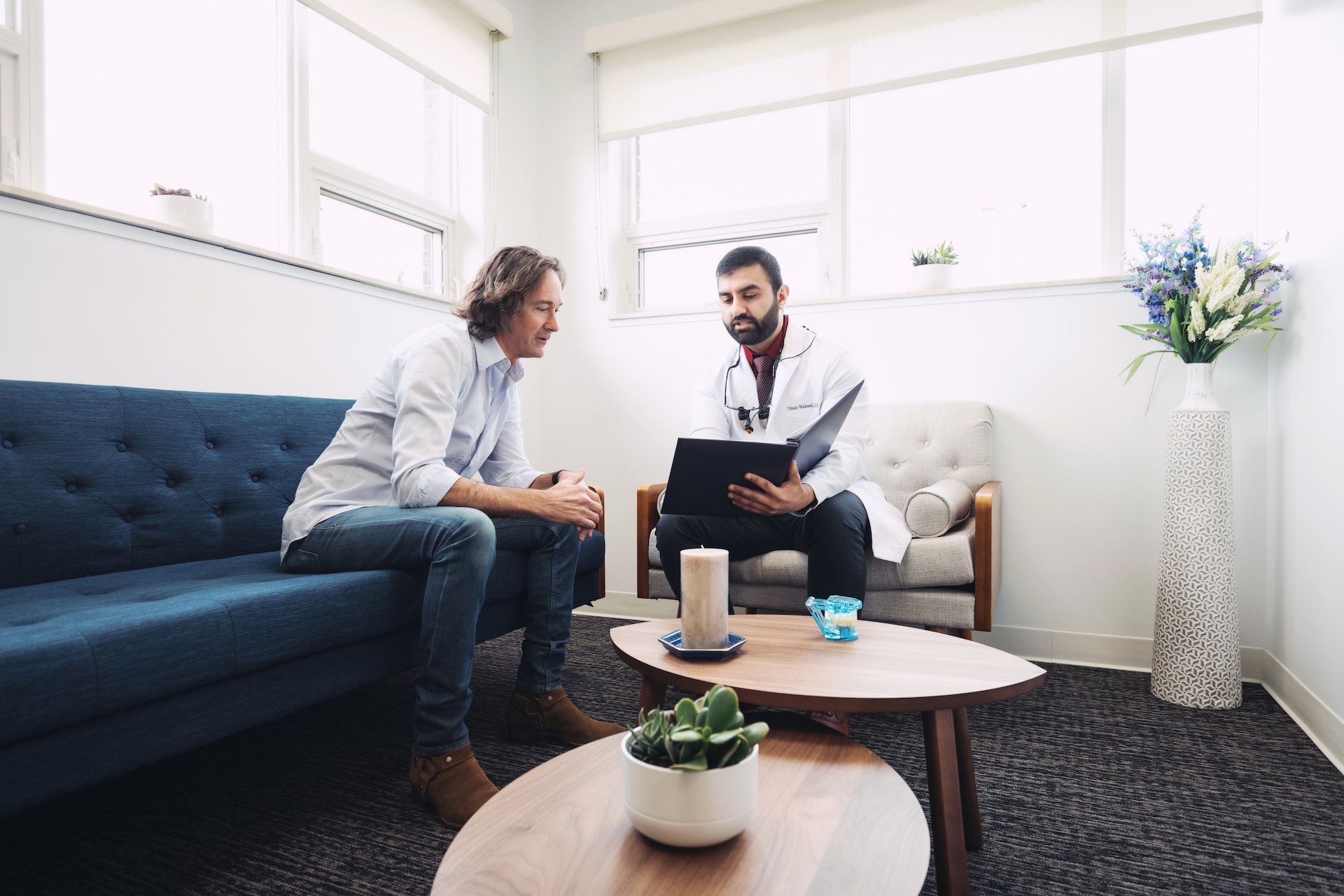 Dentist discusses dental insurance options with patient in a modern Opal Dental Group office.