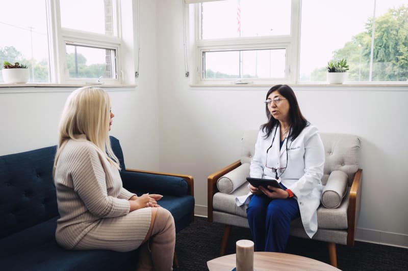 Female patient in consultation with female dentist discussing treatment in bright office