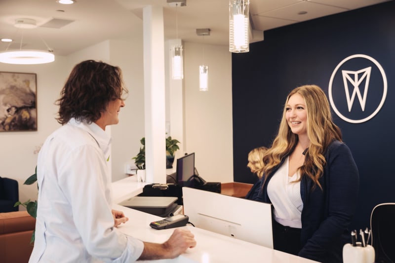 Dental professional discussing treatment plan with patient at desk