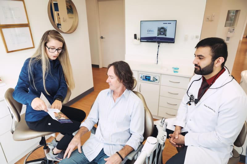 Dental professional consulting with patient in treatment room