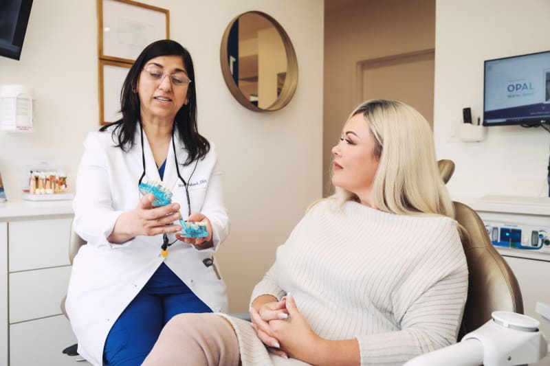 Female dentist discussing post-procedure care instructions with patient