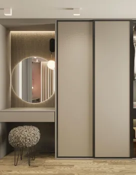 Modern vanity area with a large round mirror, integrated lighting, cushioned stool, and adjacent sliding wardrobe doors.