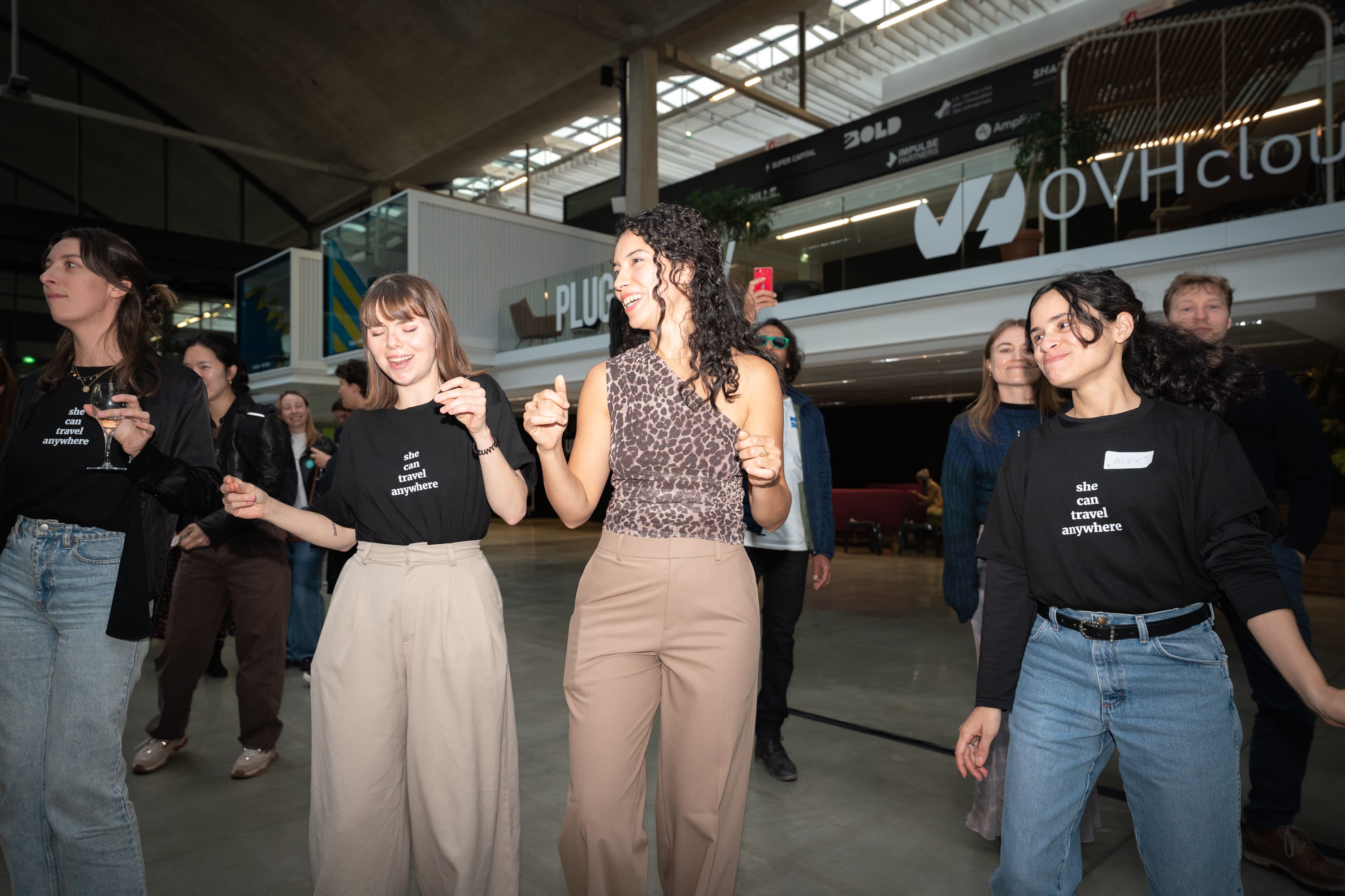 Group of diverse young adults smiling and dancing indoors in a modern open space.