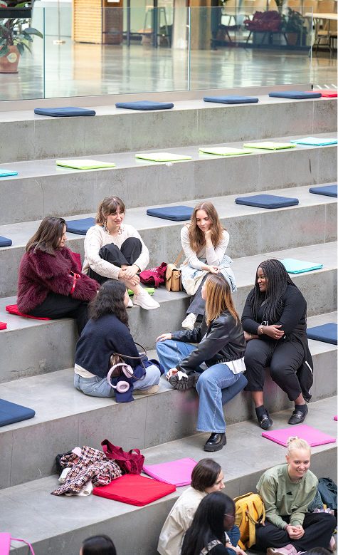 Women chatting on stepped seating with colorful cushions