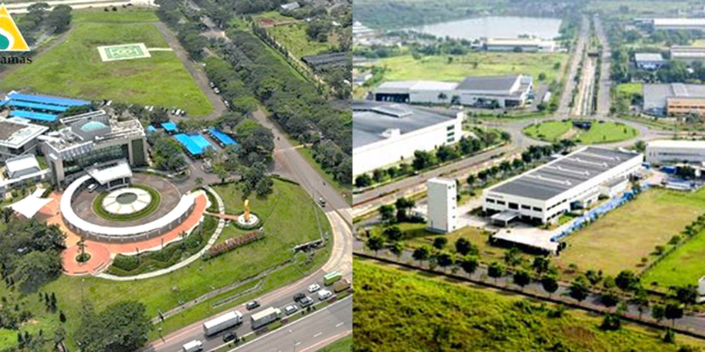 Aerial view of an industrial area with multiple buildings, green spaces, roads, and vehicles.