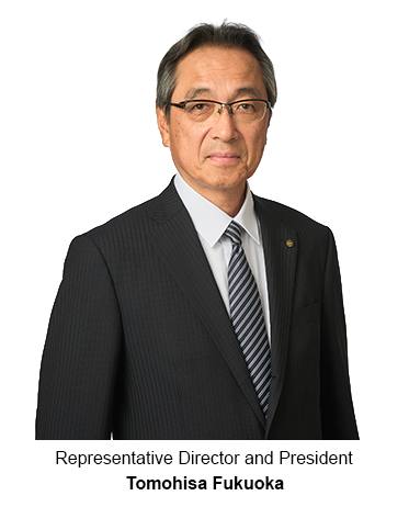 Portrait of a man in a dark suit and glasses on a white background.