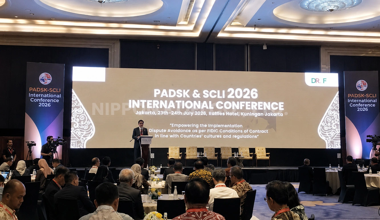 Speaker at podium addressing attendees at PADSK & SCLI 2026 international conference in a large hall.