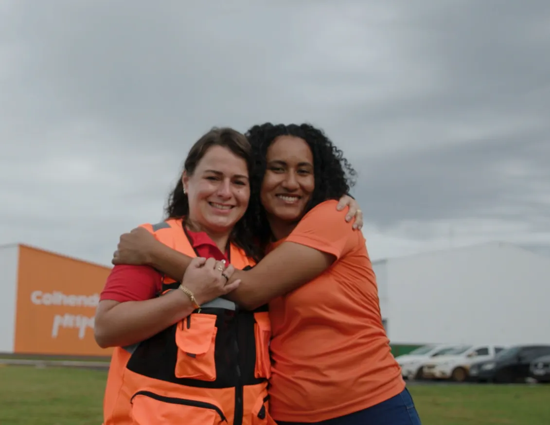 Duas pessoas do time Grupo Conceito se abraçando e sorrindo