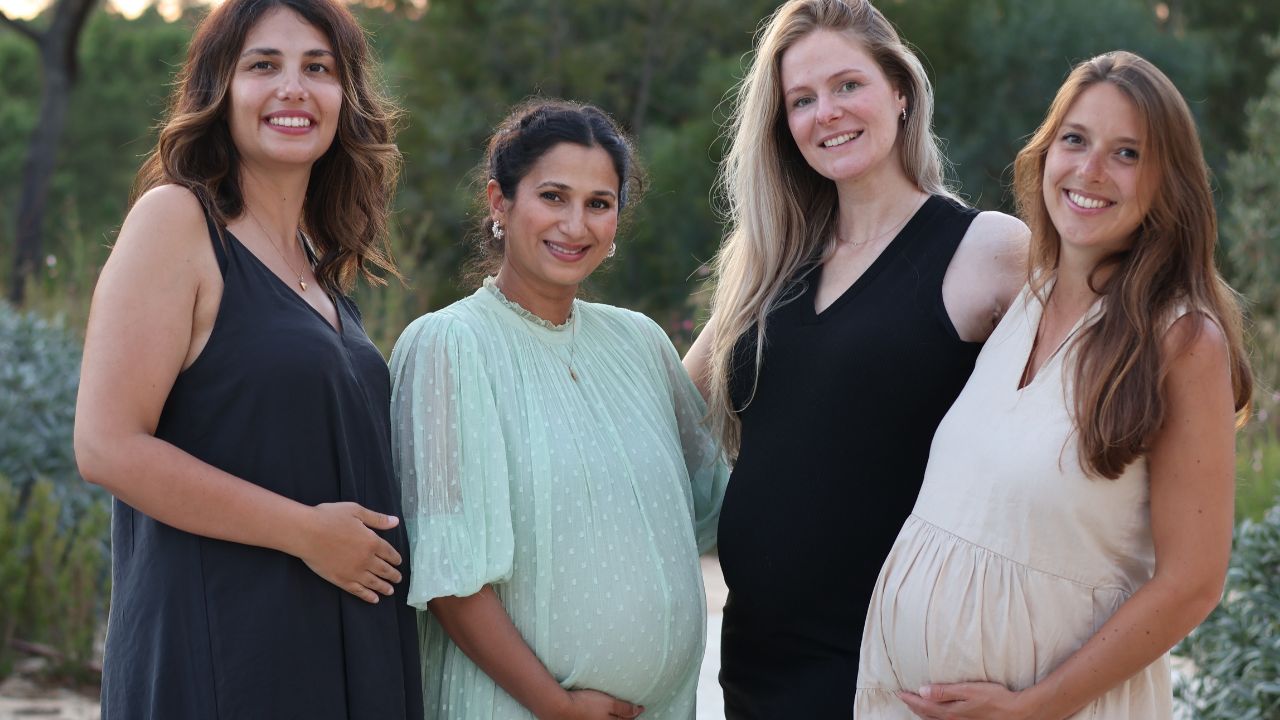Four pregnant women together in evening light at a mom'z retreat