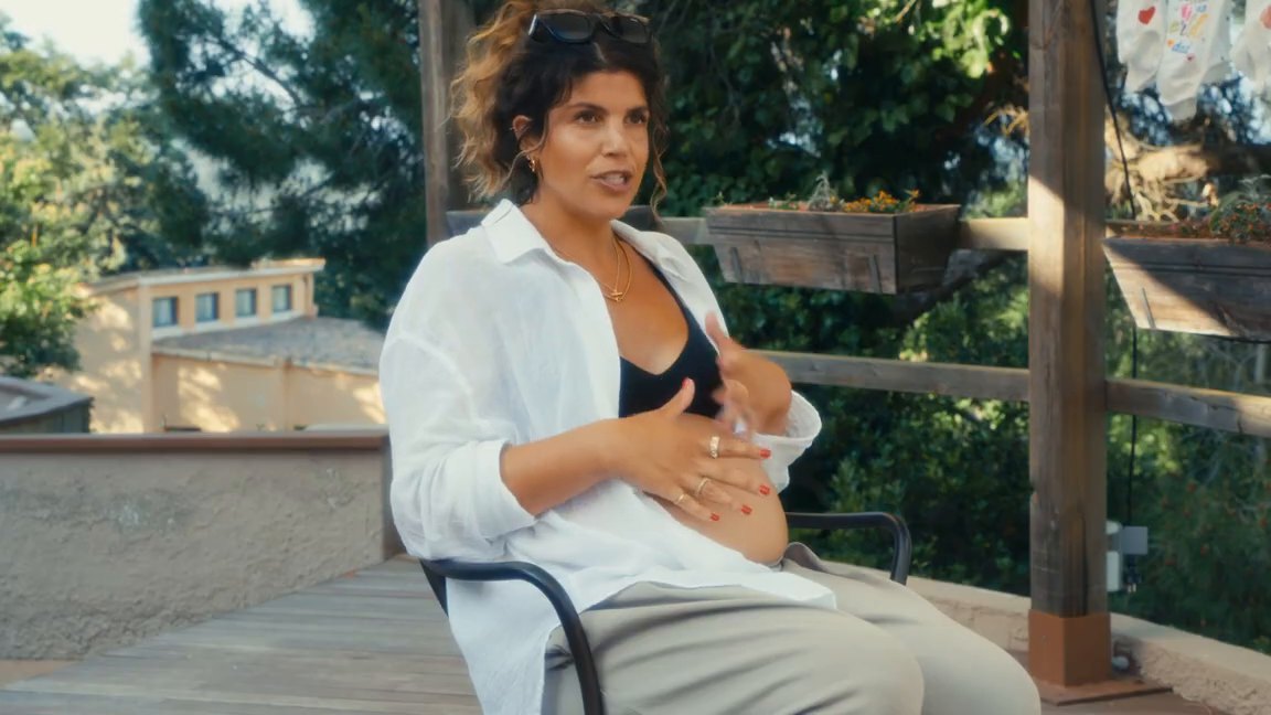 Pregnant woman speaking on the wooden terrace at a mom'z retreat
