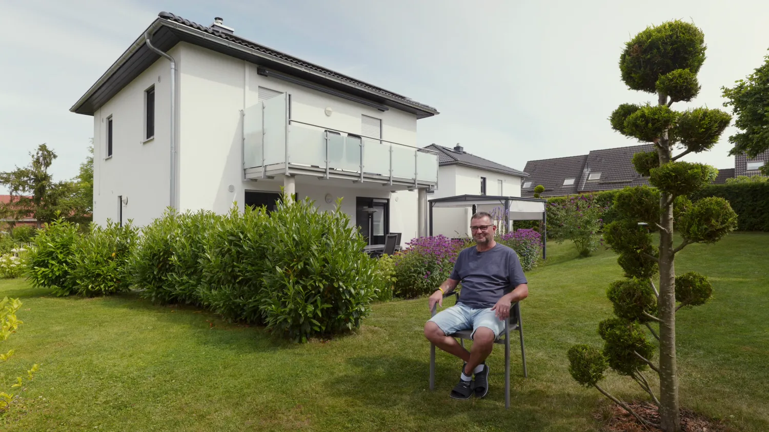 Juno-Solar-Kunde im Interview vor seinem Einfamilienhaus.