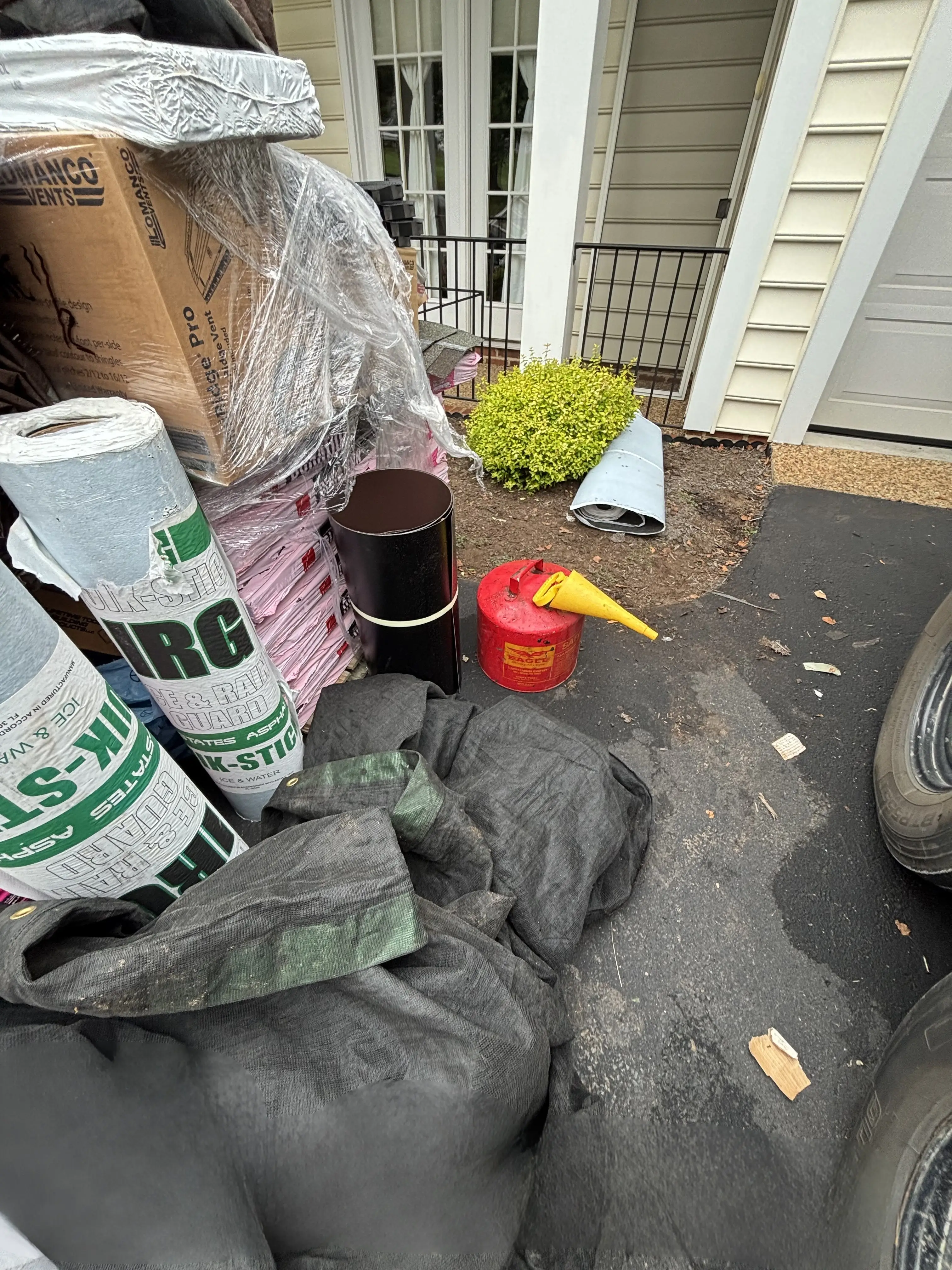 Organized roofing materials and tools staged safely during roof replacement in Charlottesville VA.