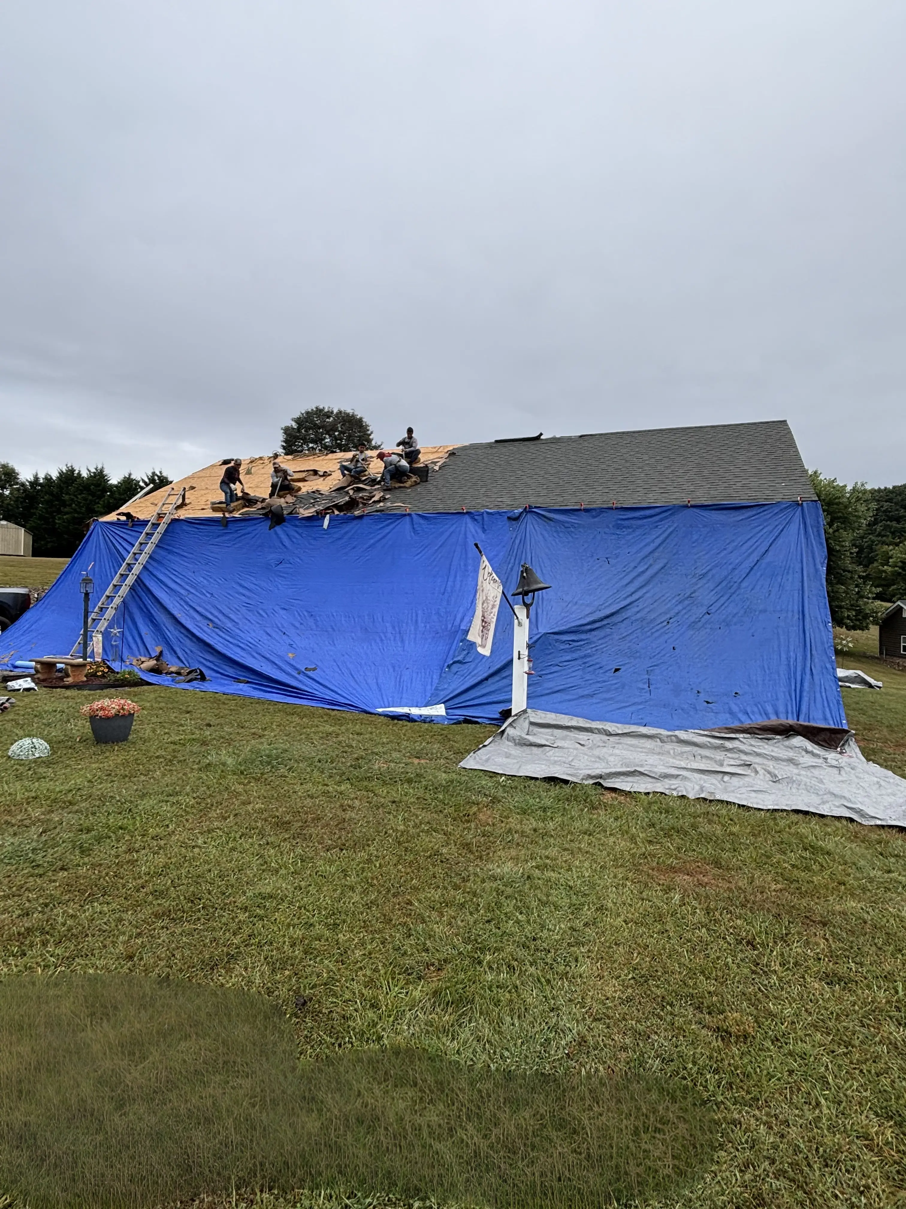 Tarps protecting siding and windows during roof replacement in Bedford VA.