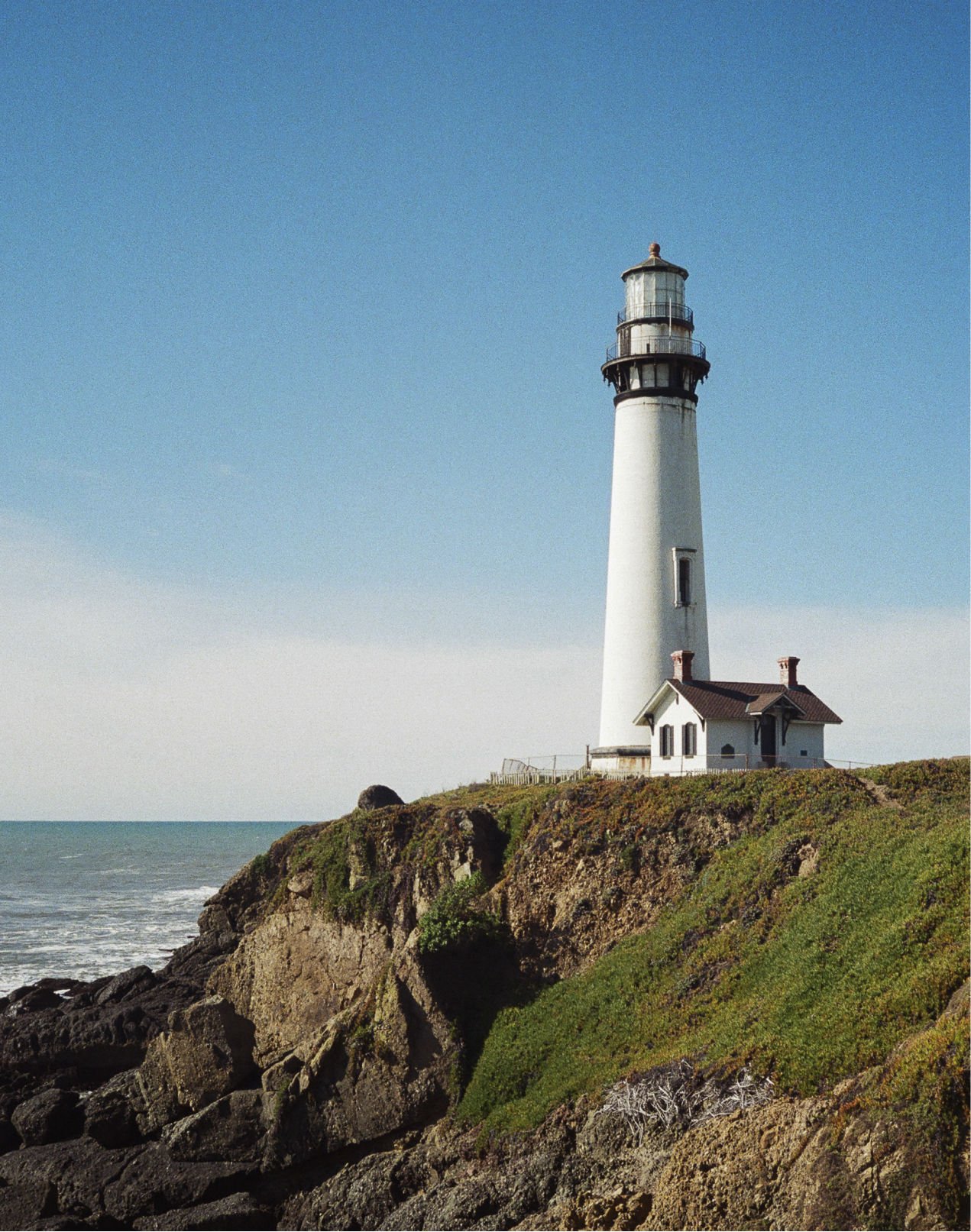 A photo of a lighthouse on a cliff