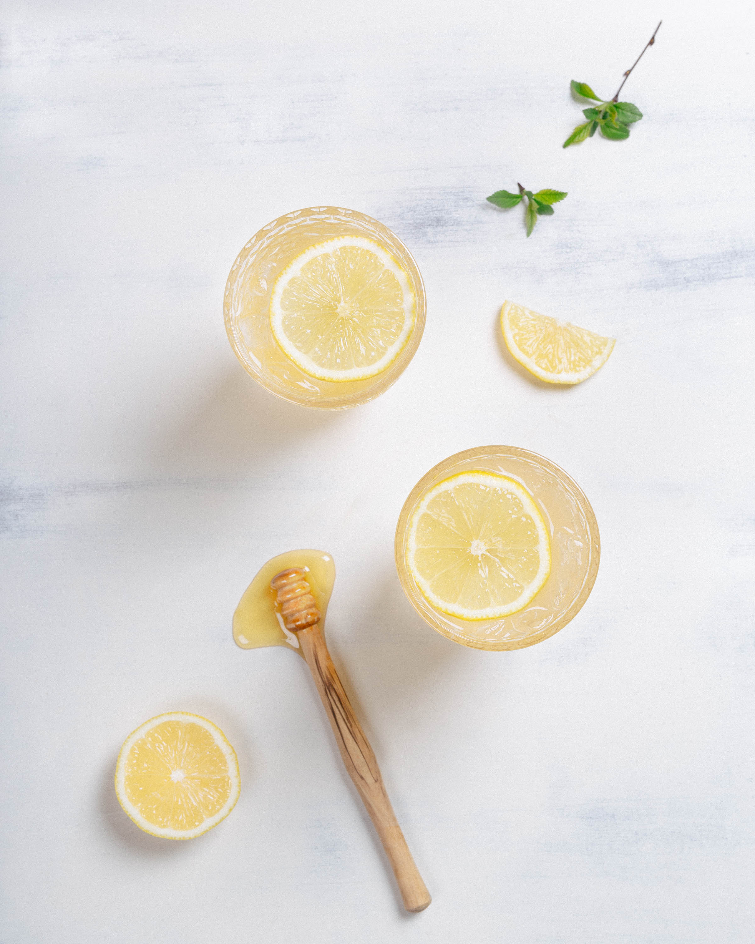 Photo of two lemon drinks with honey and lemon decorations