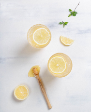 Photo of two lemon drinks with honey and lemon decorations