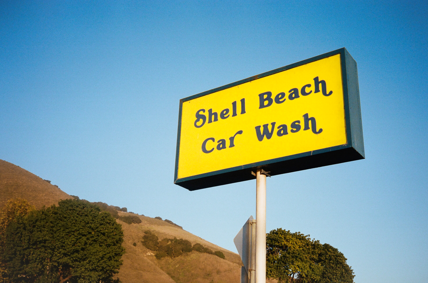 Photo of a yellow Shell Beach Car Wash sign