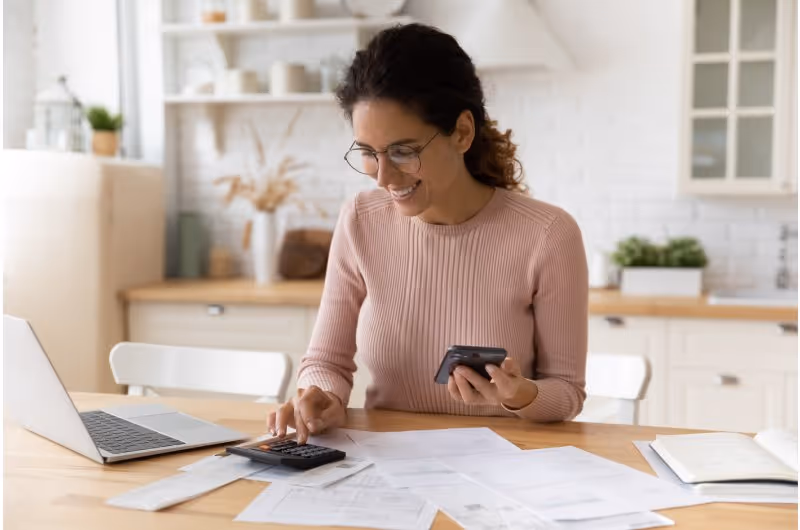 Mujer haciendo un presupuesto con calculadora y laptop