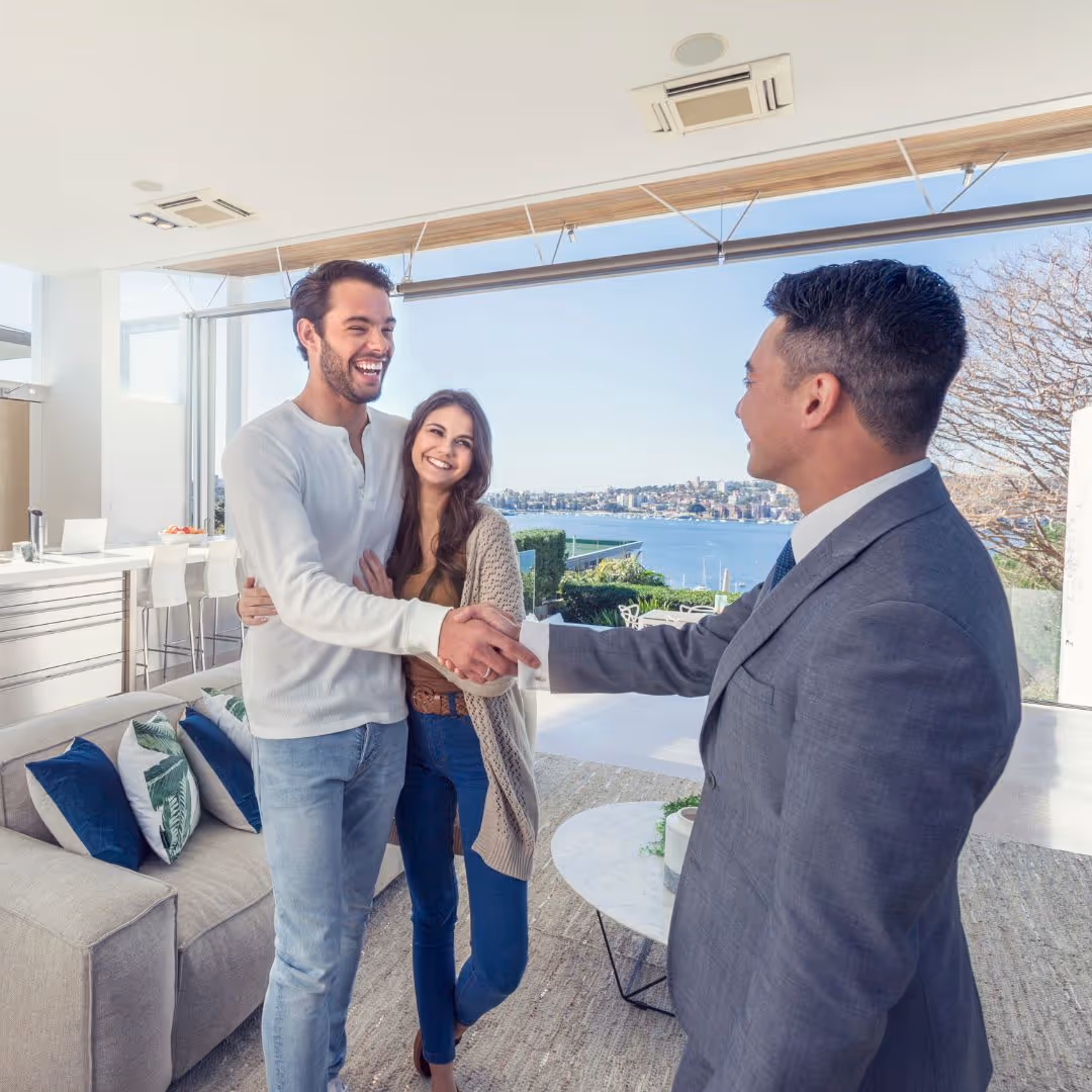 young couple shaking hands with real estate agent
