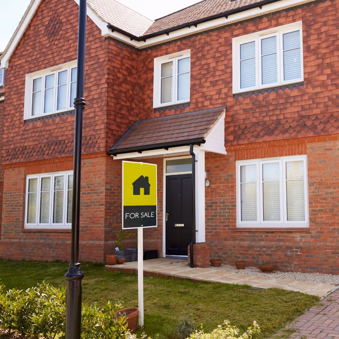 house with for sale sign in front