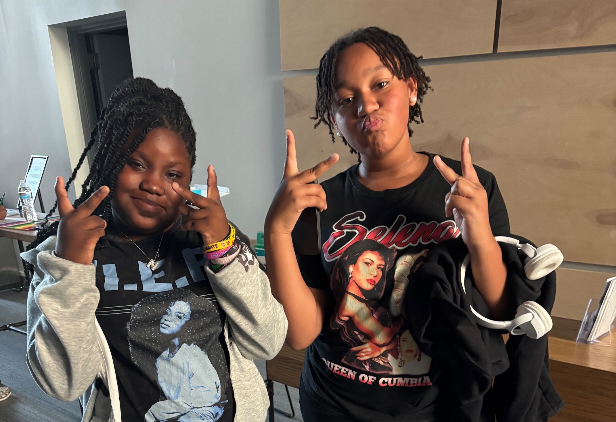 Two middle school girls giving peace signs.