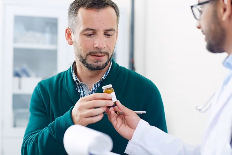 A physician prescribing medicine to his patient in his office