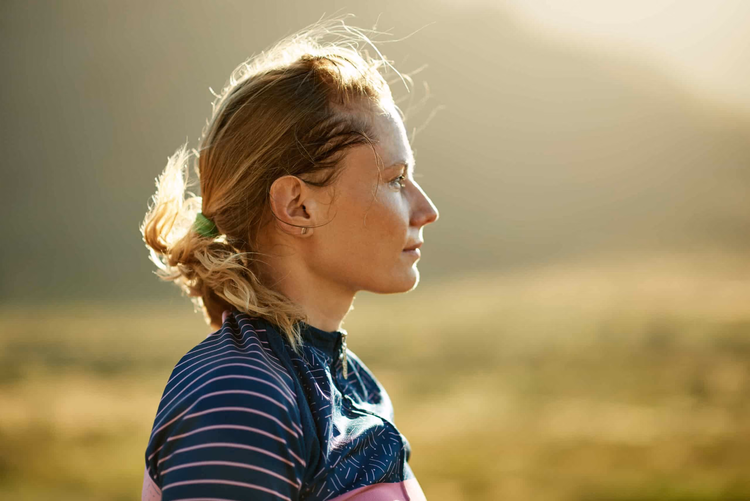 Blonde woman staring straight out in a field