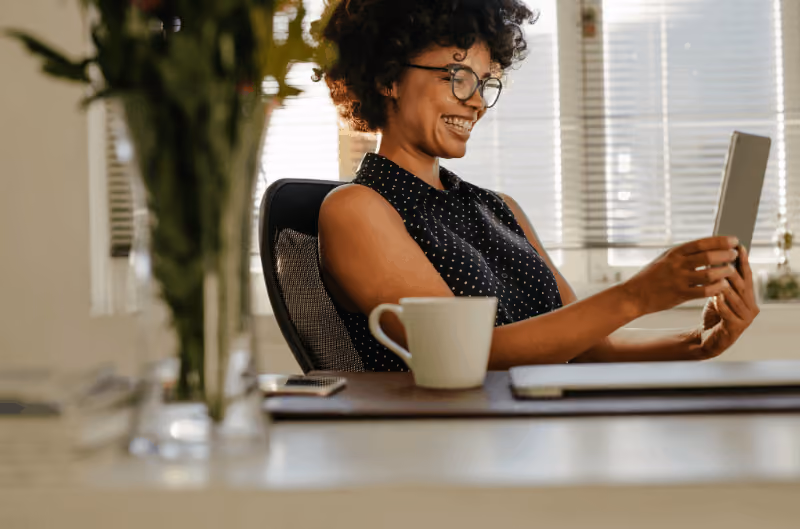 Woman smiling while holding a smart tablet