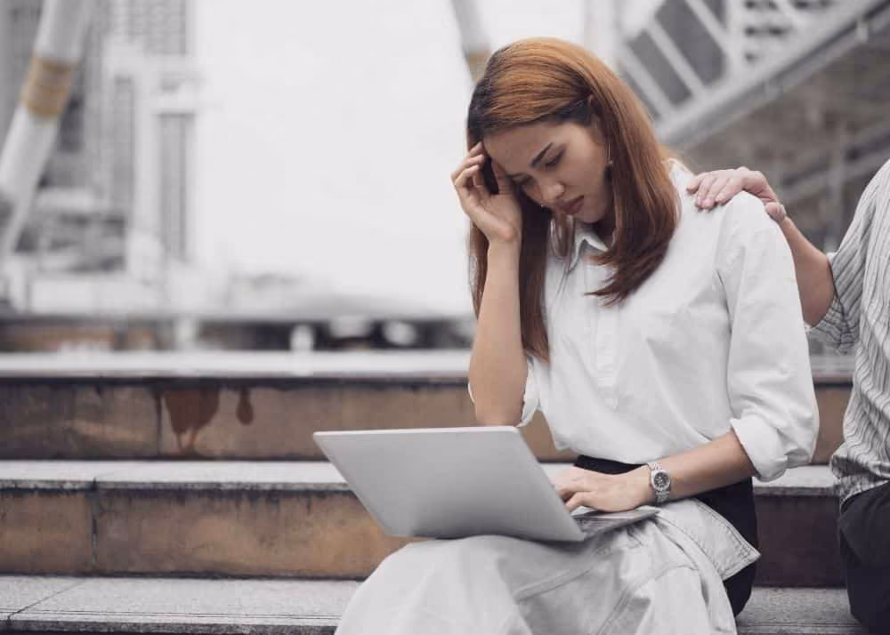 Woman being consuled while looking at a laptop screen