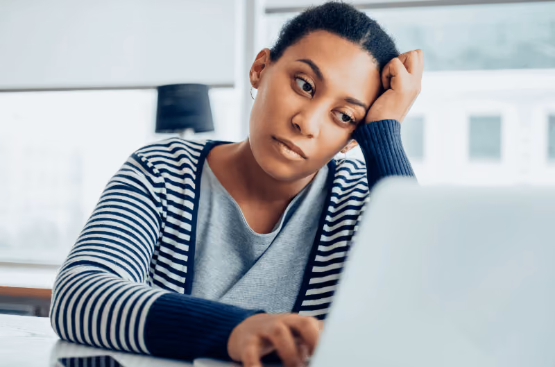 Woman experiencing depression symptoms while working on a laptop
