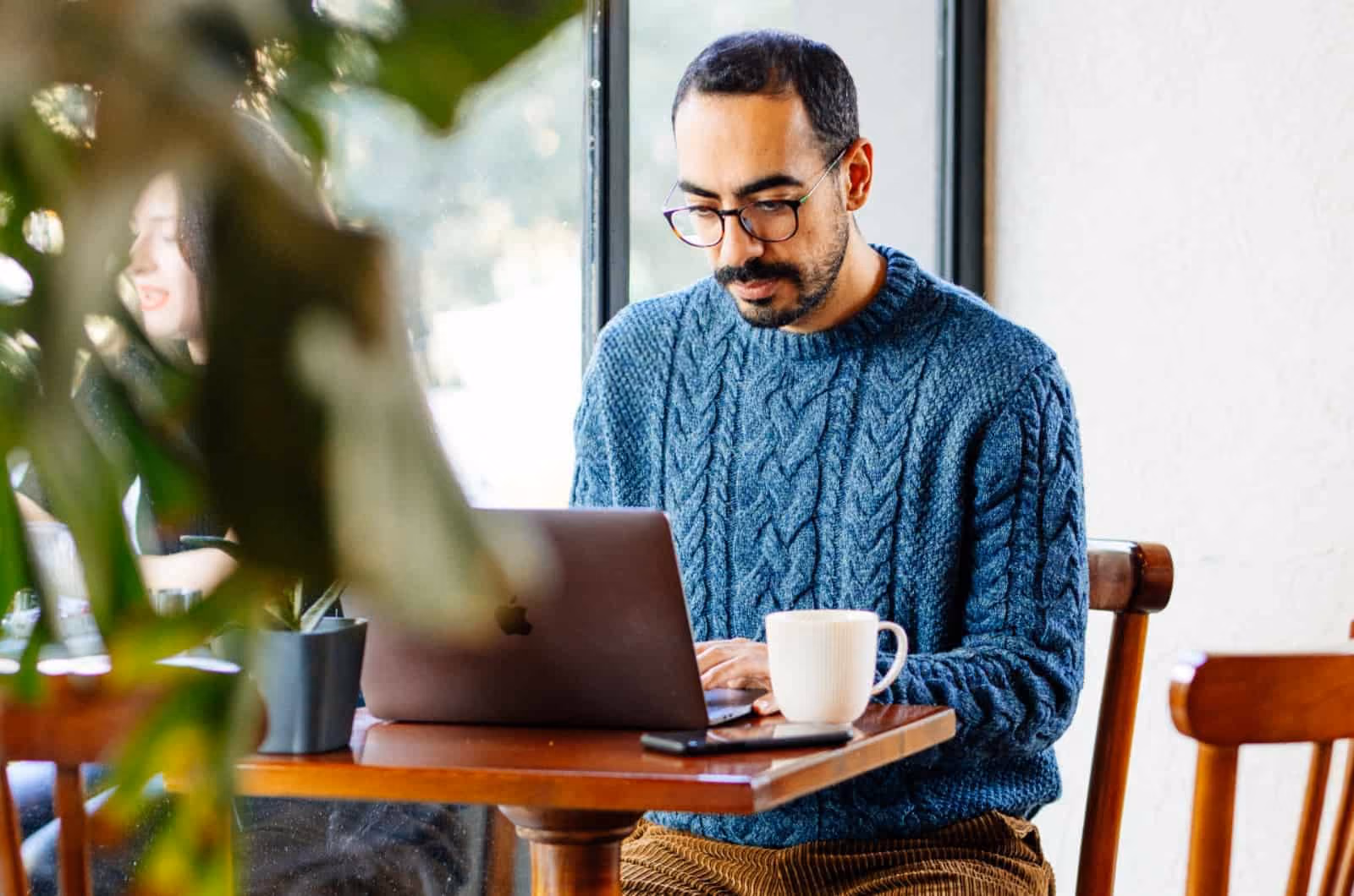 Man in a knit sweater monotasking to remain focused at work