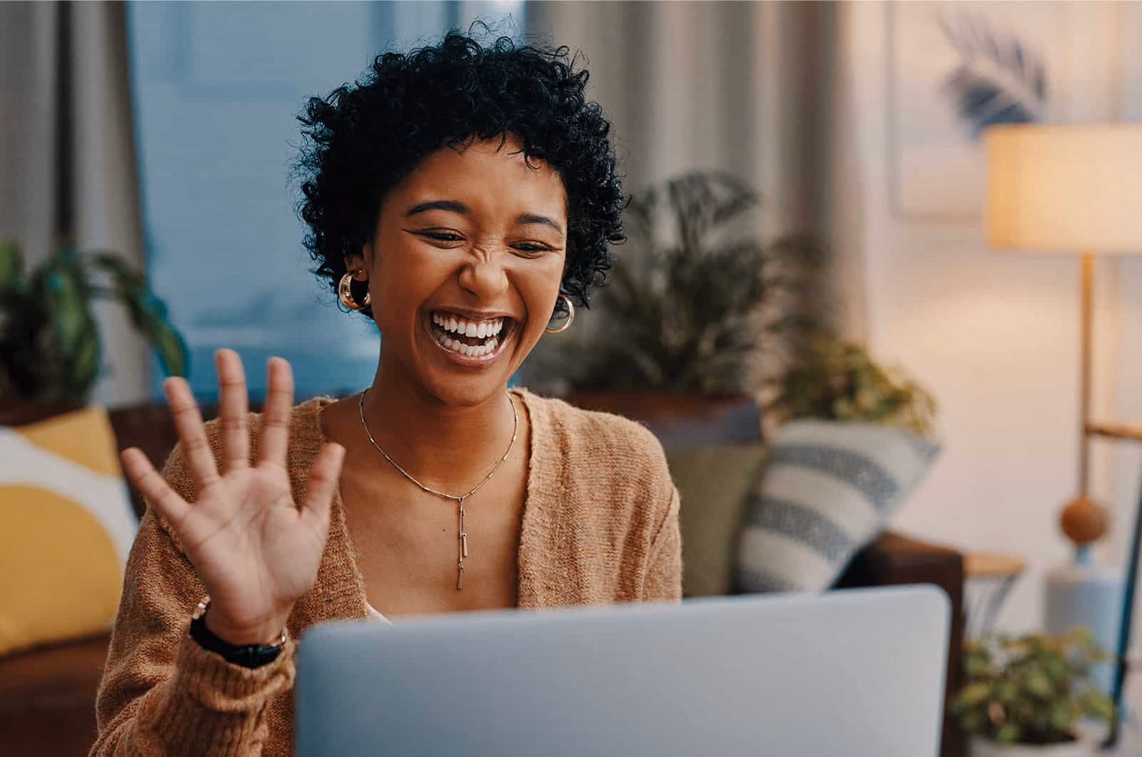 Woman smiling and waving at someone on a virtual call