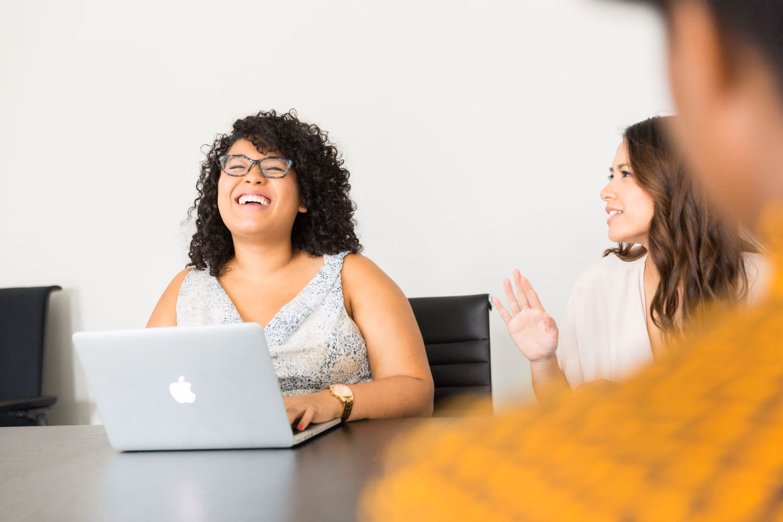 Woman laughing on a laptop in an office