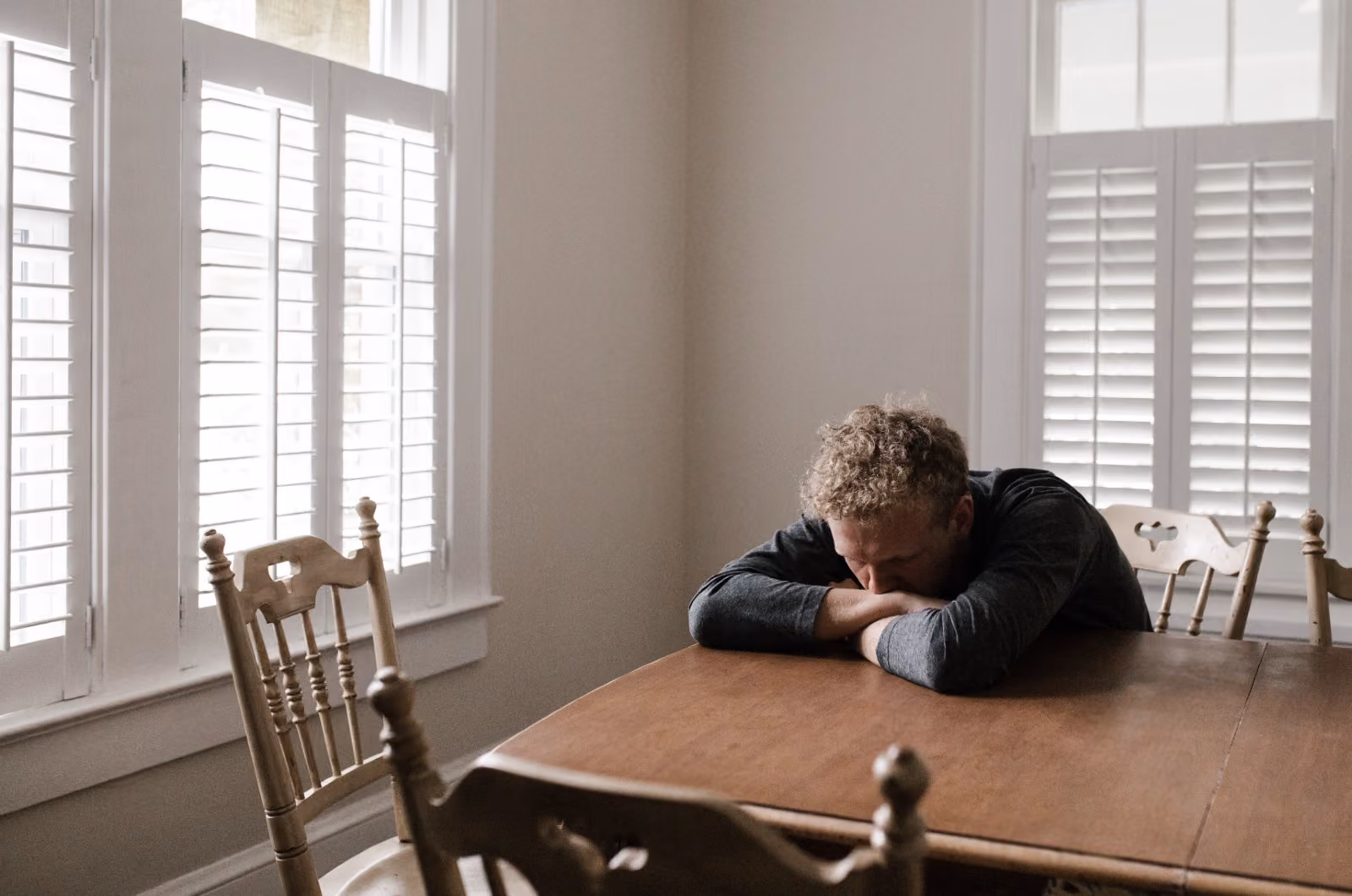Man tiredly resting his head on a table