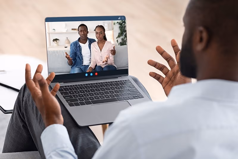 Couples therapist taking a call virtually with a young couple