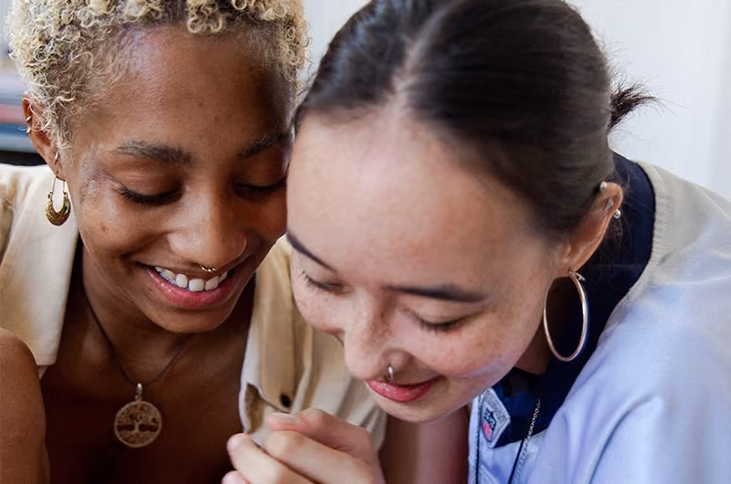 Gen Z employees huddled next to each other smiling