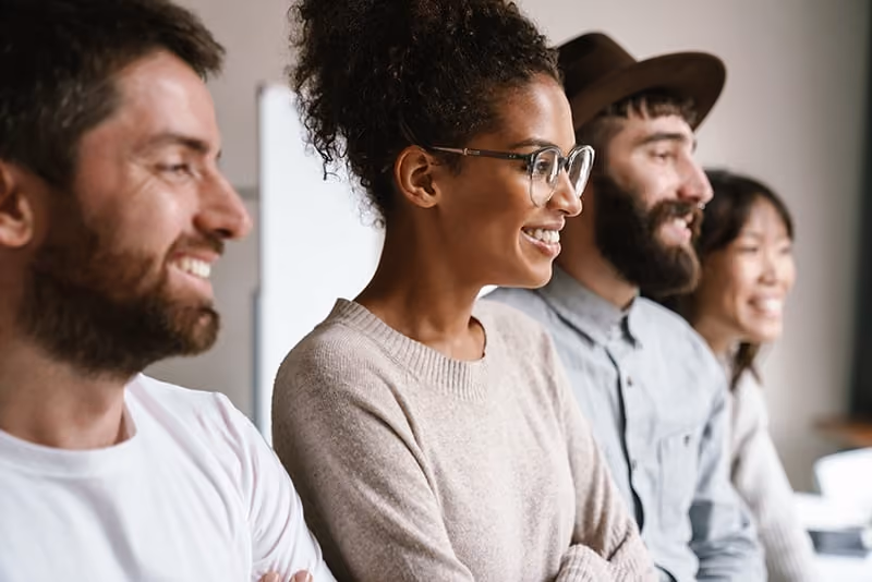 Various employees looking to the right and smiling