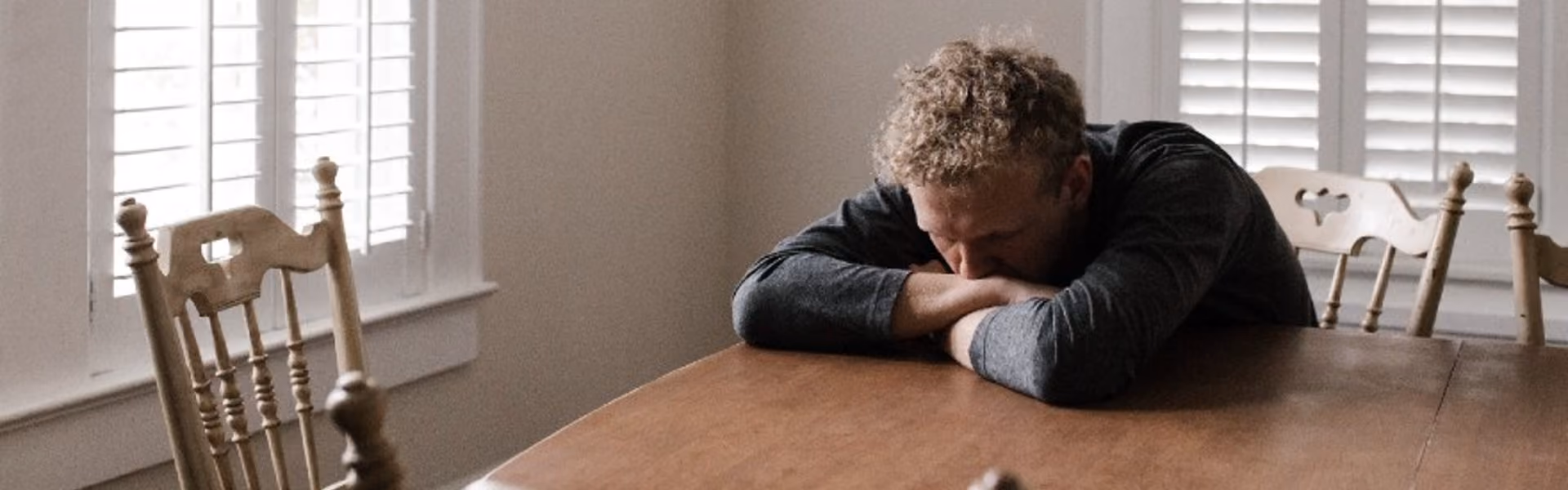Man tiredly resting his head on a table