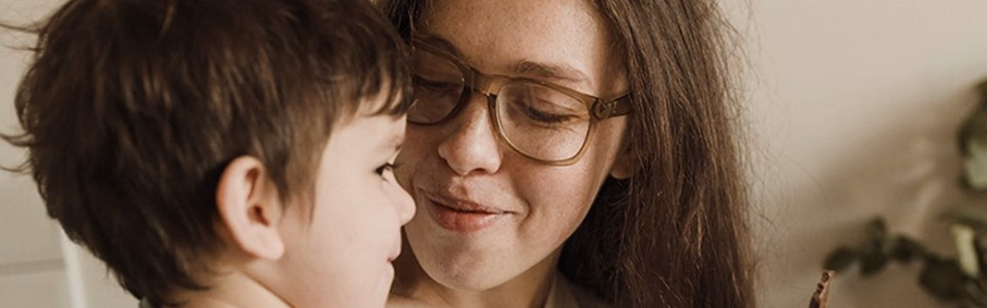 A woman with glasses holding her autistic son