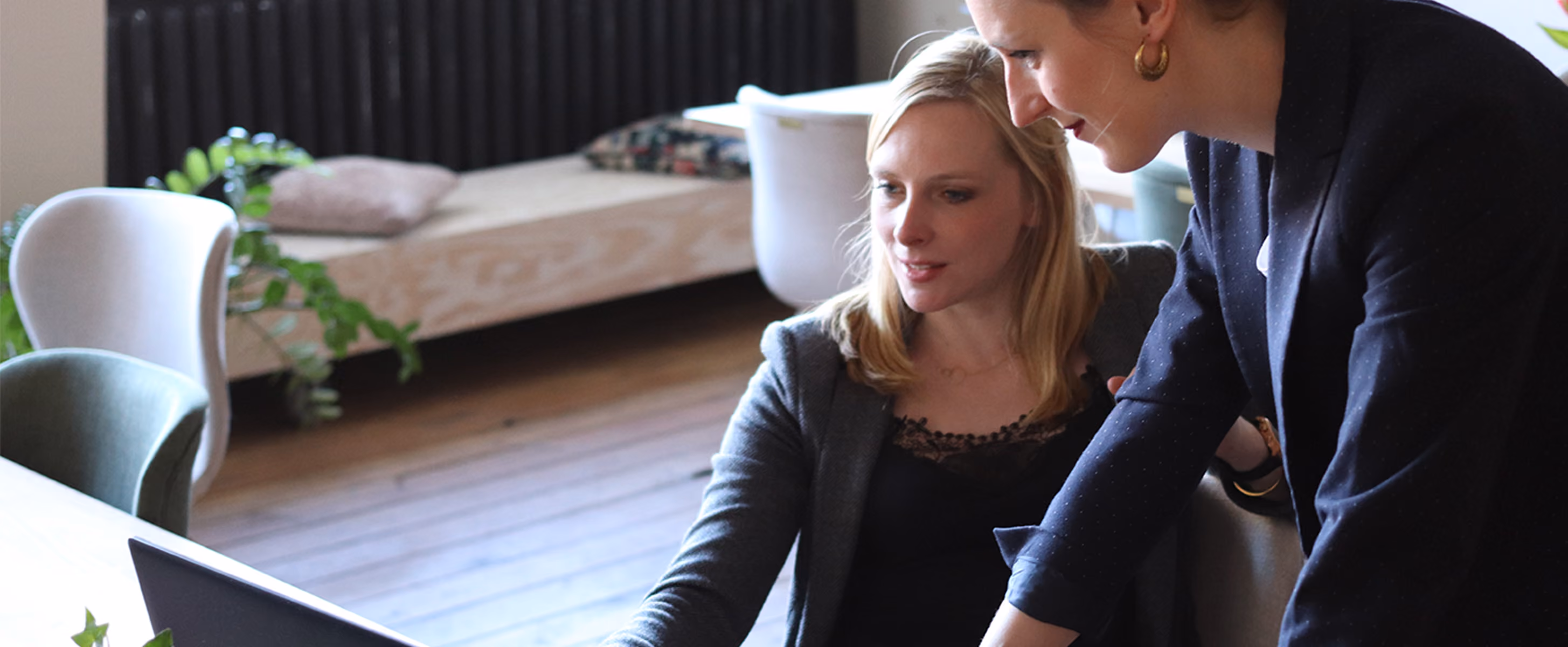 Two women in the workplace looking at a document on a laptop