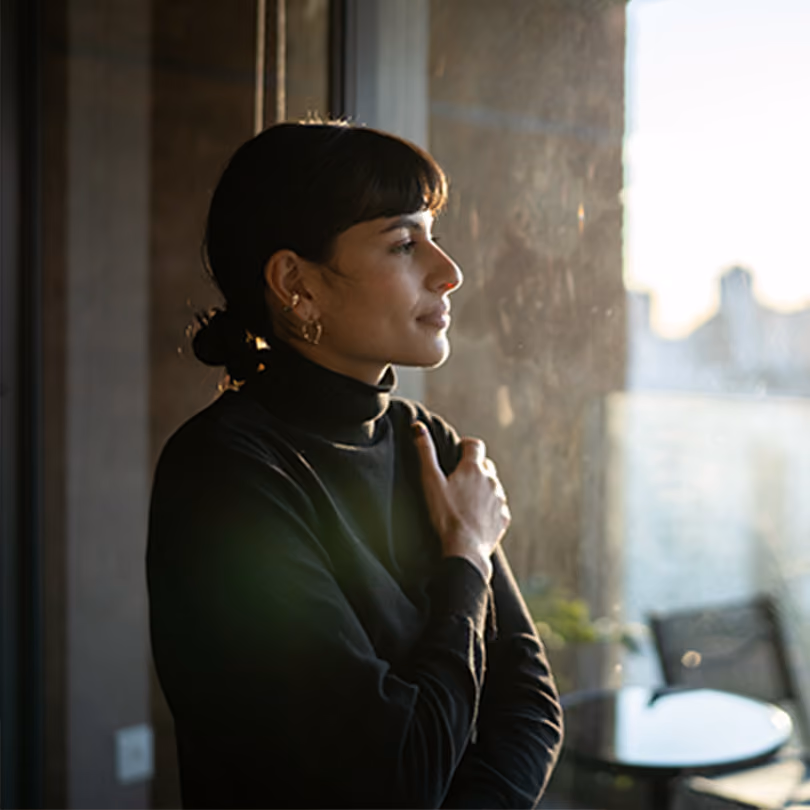 A dark-haired business woman is experiencing the benefits of a mindfulness practice at work